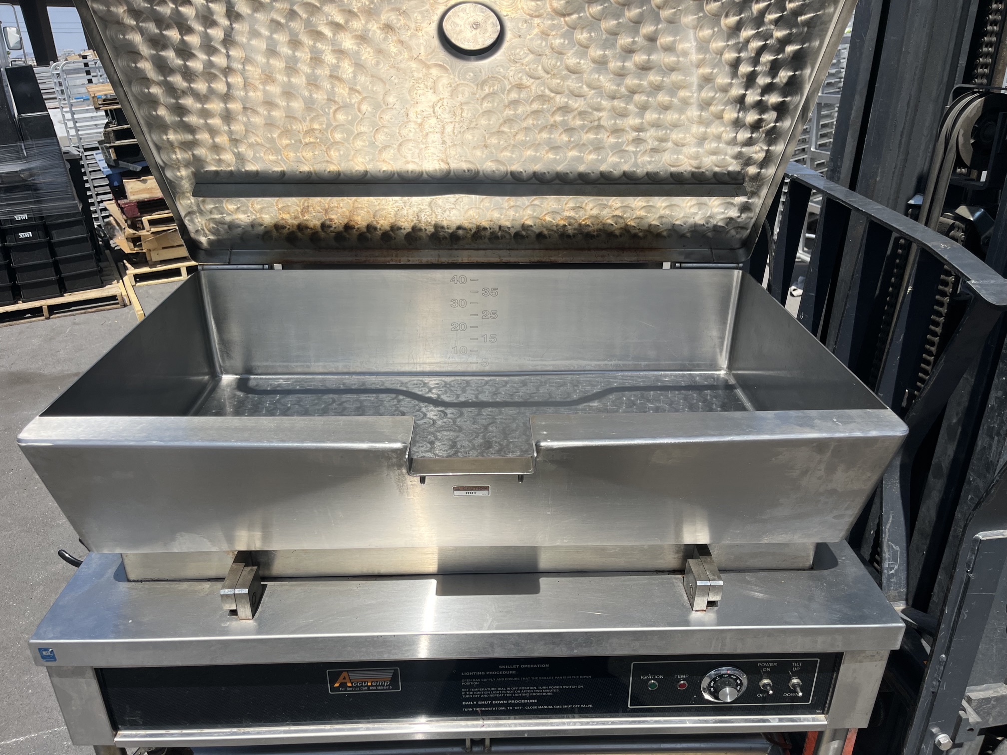 AccuTemp ACGLTS-40 tilt skillet with lid open showing stainless steel pan interior with gallon markings from 10 to 40 and dimpled pan bottom