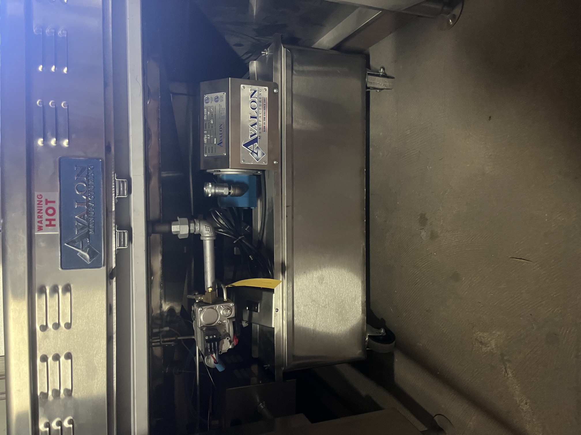 Avalon ARF34-G oil filtration system stored under the fryer on casters with Avalon branding visible