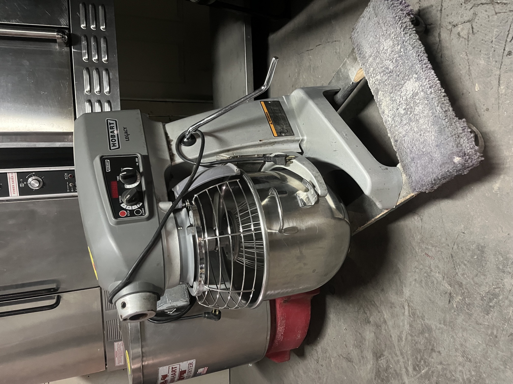 Hobart Legacy HL200 20-quart planetary mixer with stainless steel bowl, wire whip attachment, and bowl guard on warehouse floor