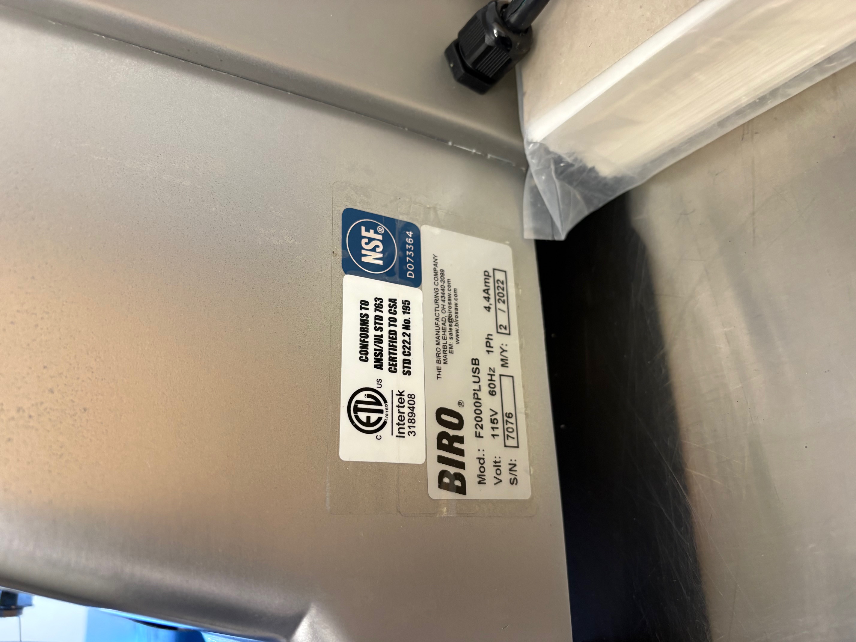 Close-up of Biro F2000PLUSB data plate showing model number, 115V 60Hz 1Ph 4.4Amp, serial number 7076, manufactured February 2022, ETL and NSF certifications