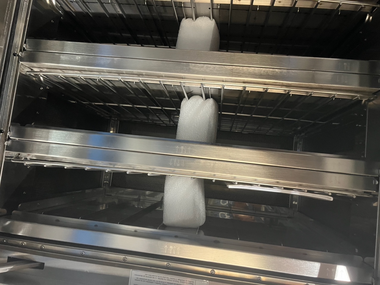Interior view of Alto-Shaam VMC-F3E showing three cooking chambers with wire racks and original factory foam packing still in place