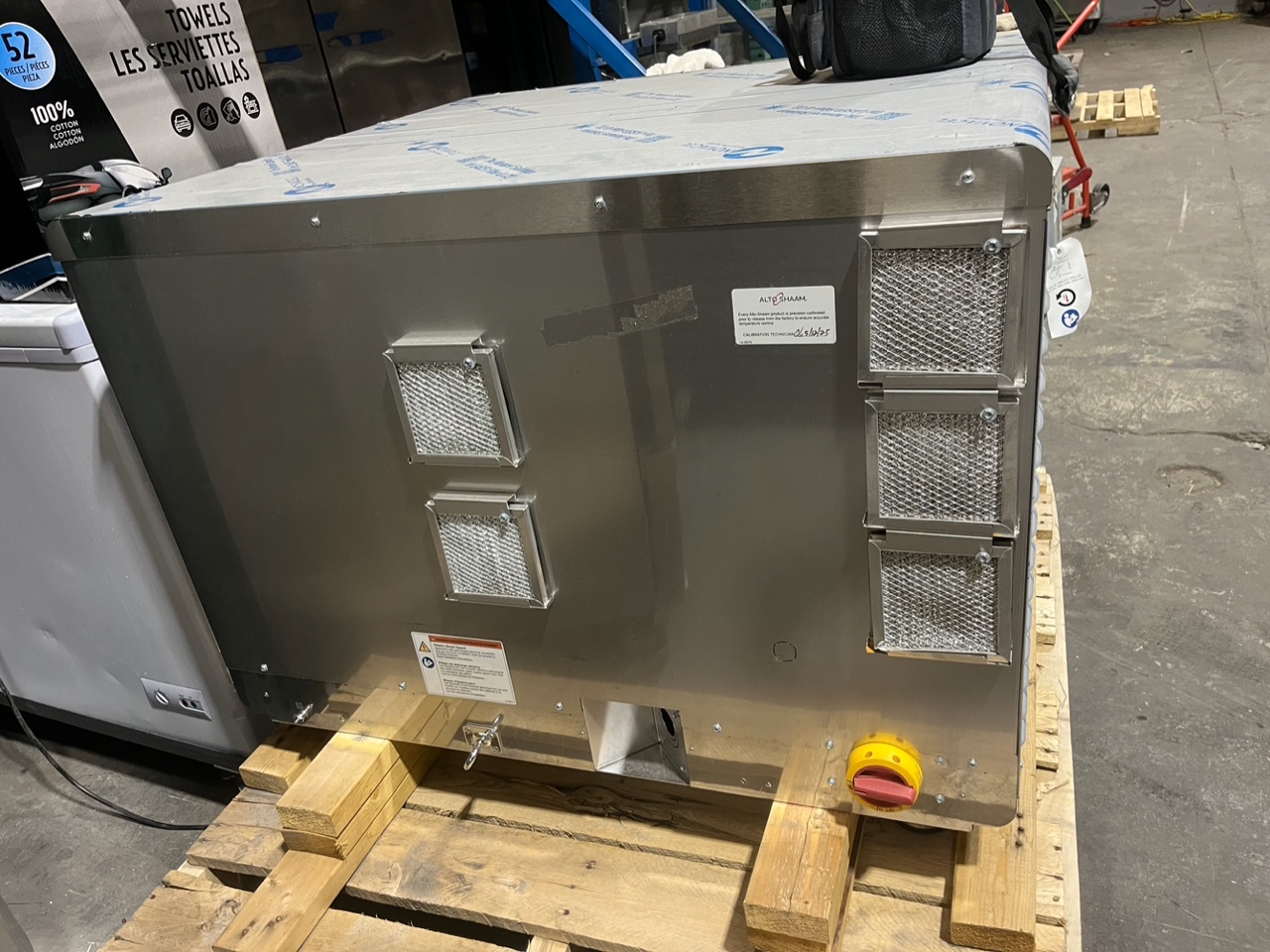 Rear view of Alto-Shaam VMC-F3E on pallet showing stainless steel back panel with ventilation filters and factory sticker