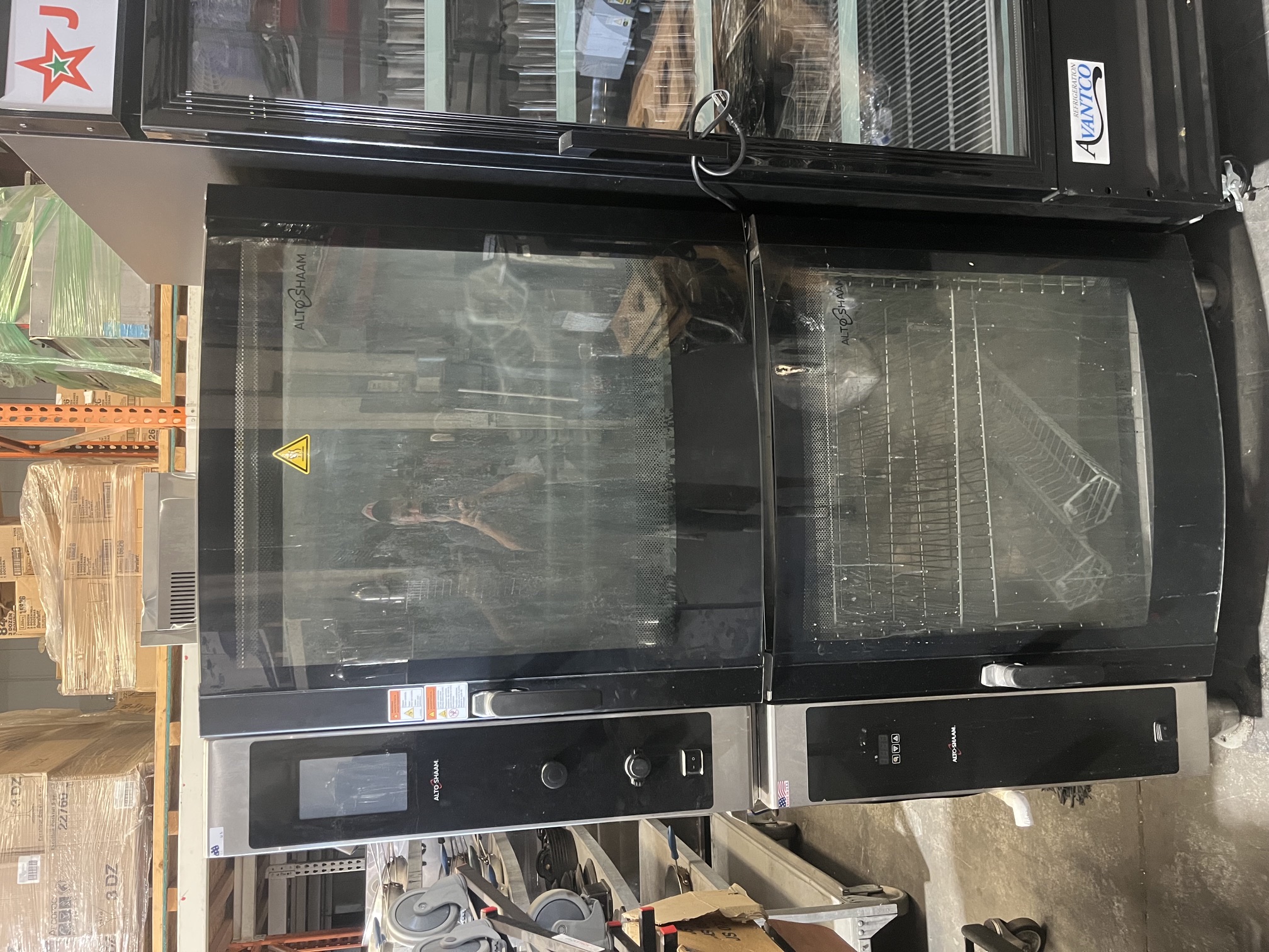 Alto-Shaam AR-7T rotisserie oven stacked on warming cabinet base with curved glass doors in warehouse setting