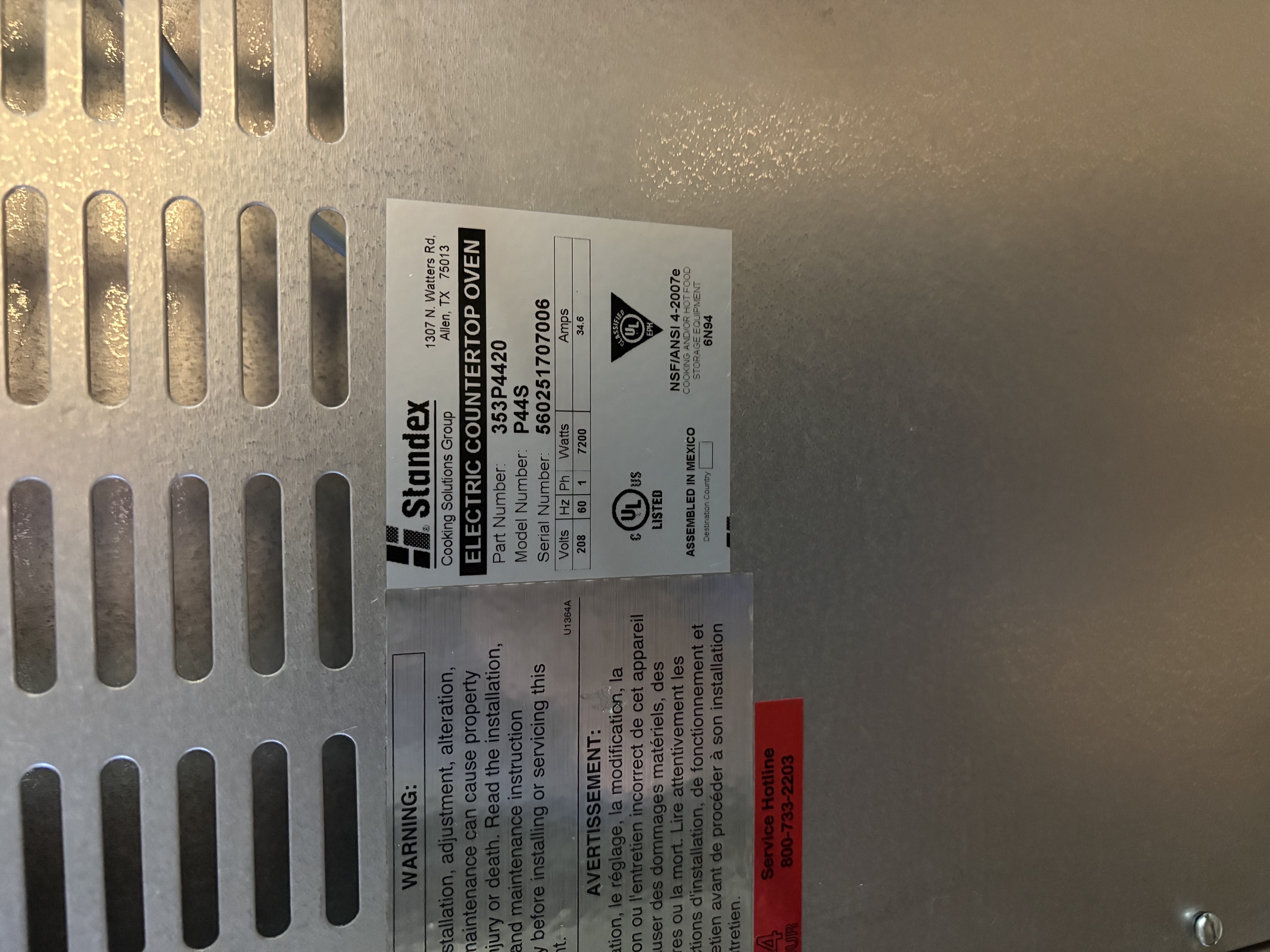 Close-up of the Standex data plate on the P44S pizza oven showing model number, serial number, electrical specs (208V, 60Hz, 1-phase, 7200W, 34.6A), and UL/NSF certifications
