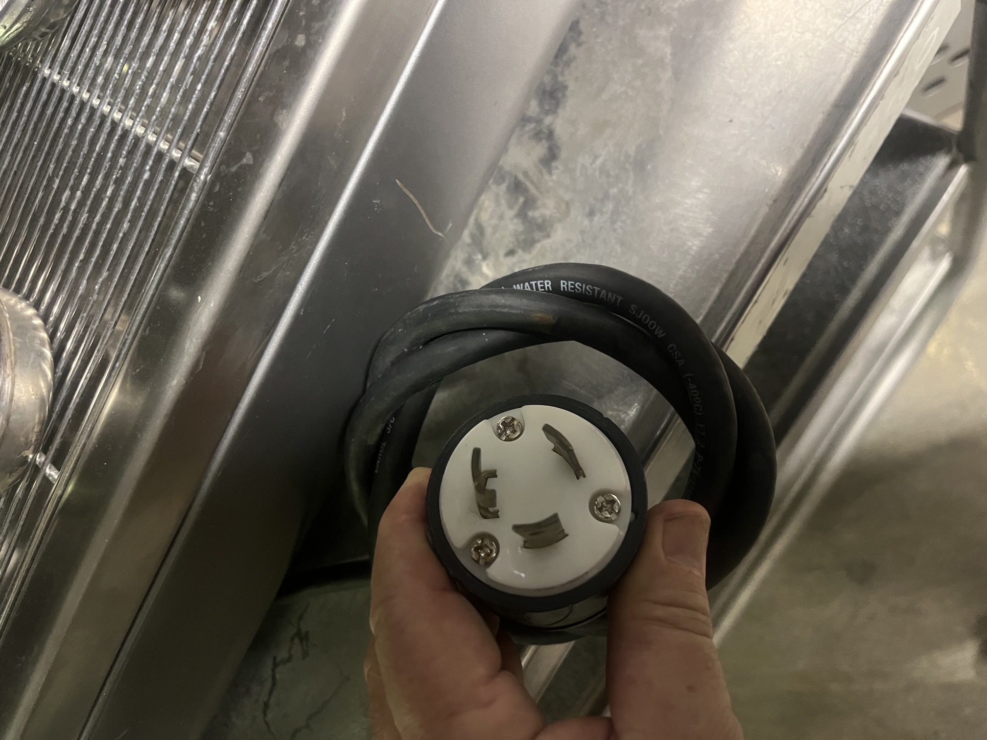 Close-up of twist-lock electrical plug (L6-30P) for the Nuova Simonelli Aurelia V espresso machine