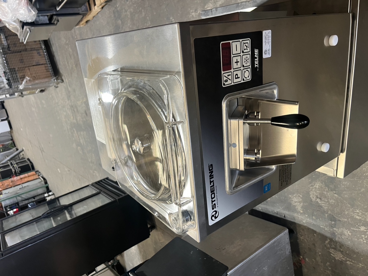 Top-angle view of Stoelting VB9-37a showing transparent hopper lid, control panel, and dispensing handle