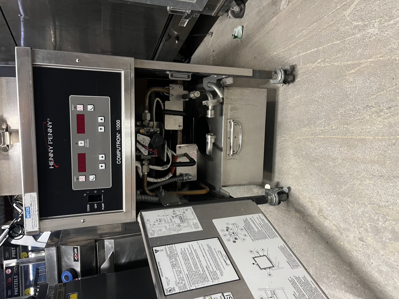 Close-up of Henny Penny Computron 1000 digital control panel with Cook/Off/Pump switch and internal components visible behind open lower panel