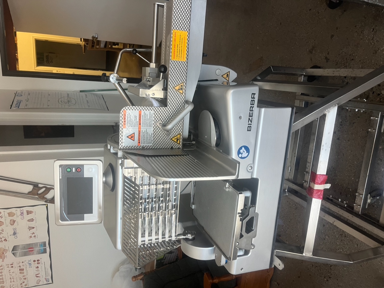 Full view of the Bizerba VSI330 F W automatic slicer on stainless steel stand with touchscreen display, conveyor, and built-in sharpener