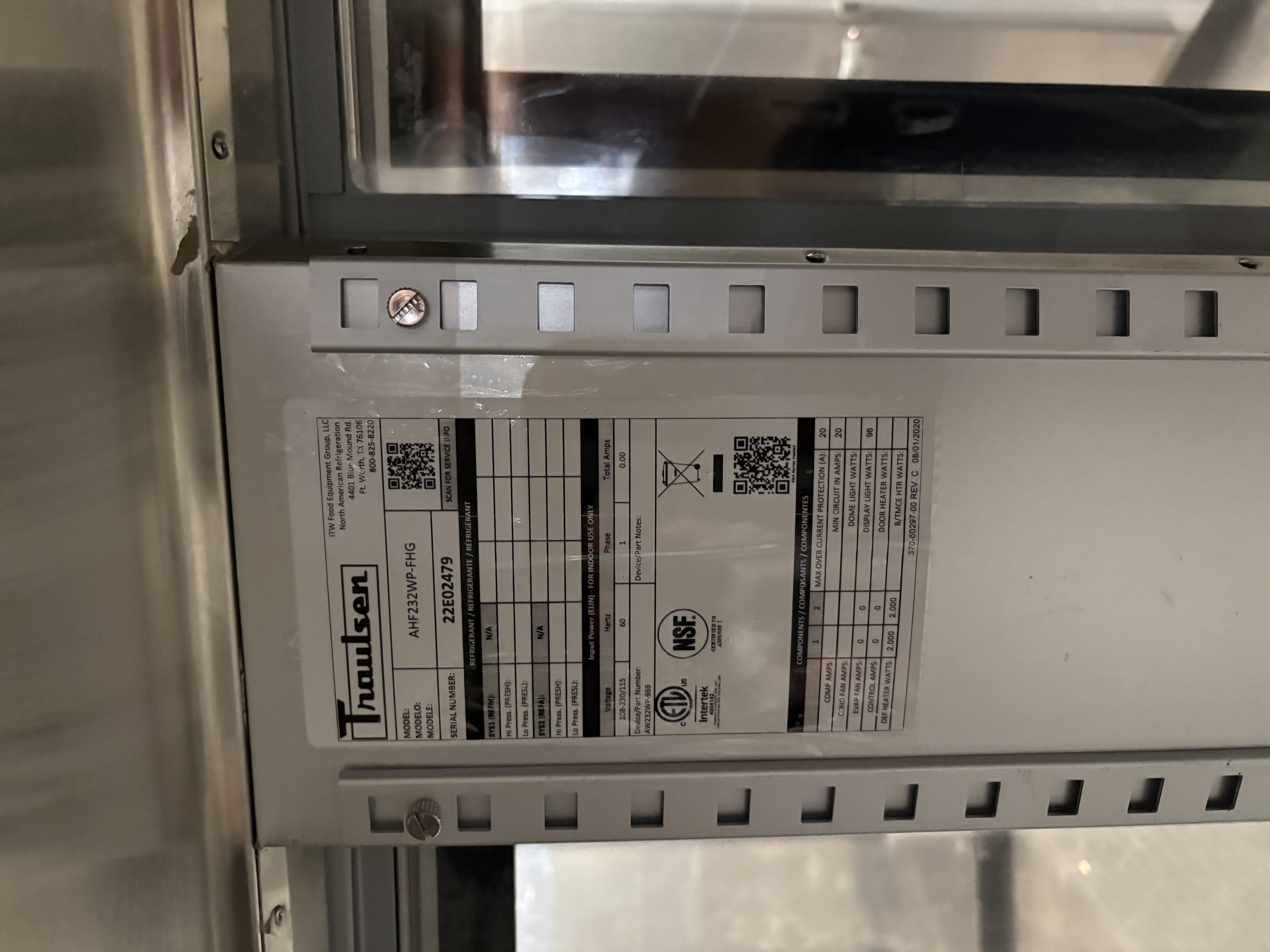 Close-up of Traulsen AHF232WP-FHG data plate showing model number, serial number 22E02479, 208-230/115V single phase electrical specifications, NSF and ETL certifications, and component amperage details
