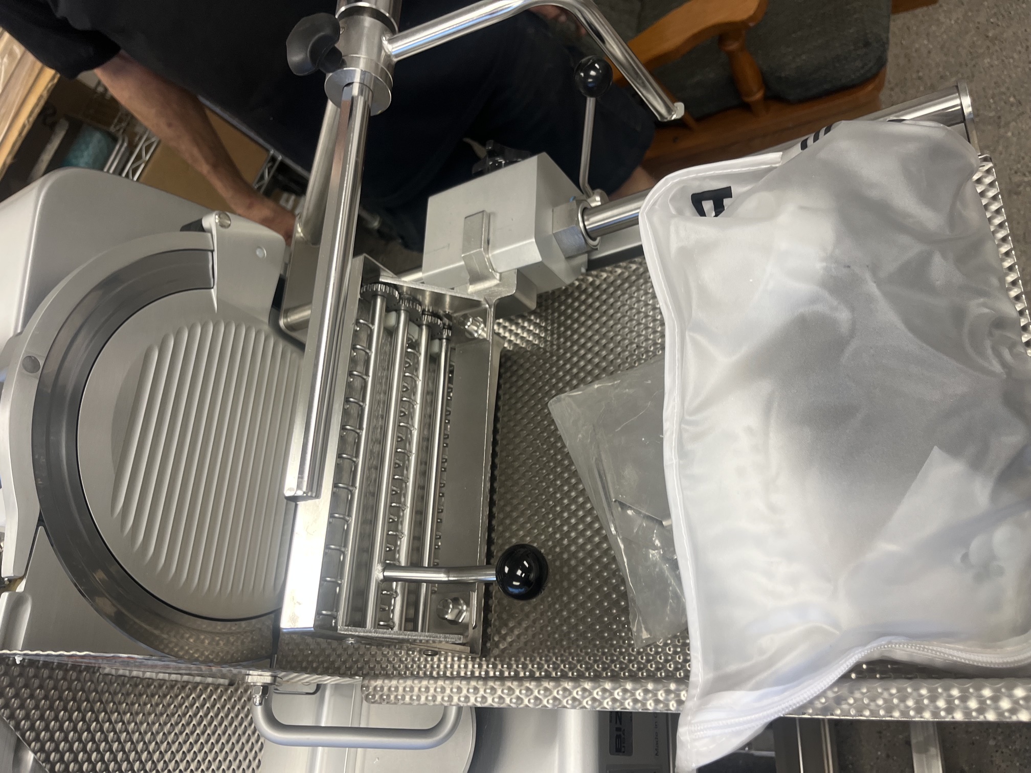 Close-up of Bizerba VSI F slicer blade area with accessories bag and original packaging materials