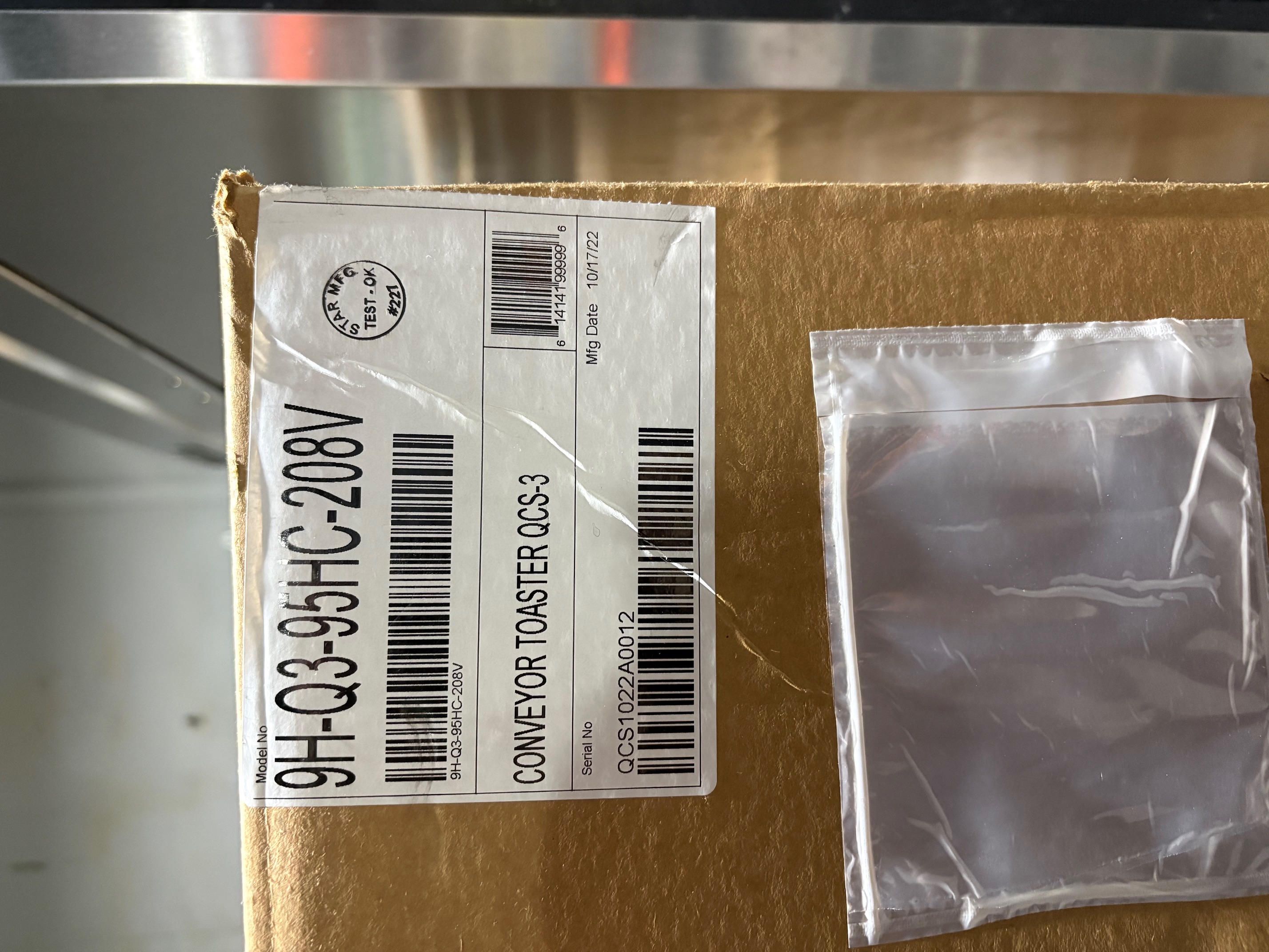 Factory label on Star QCS-3 Conveyor Toaster box showing model 9H-Q3-95HC-208V, serial number, manufacture date 10/17/2022, and Star MFG Test OK stamp — new in original packaging