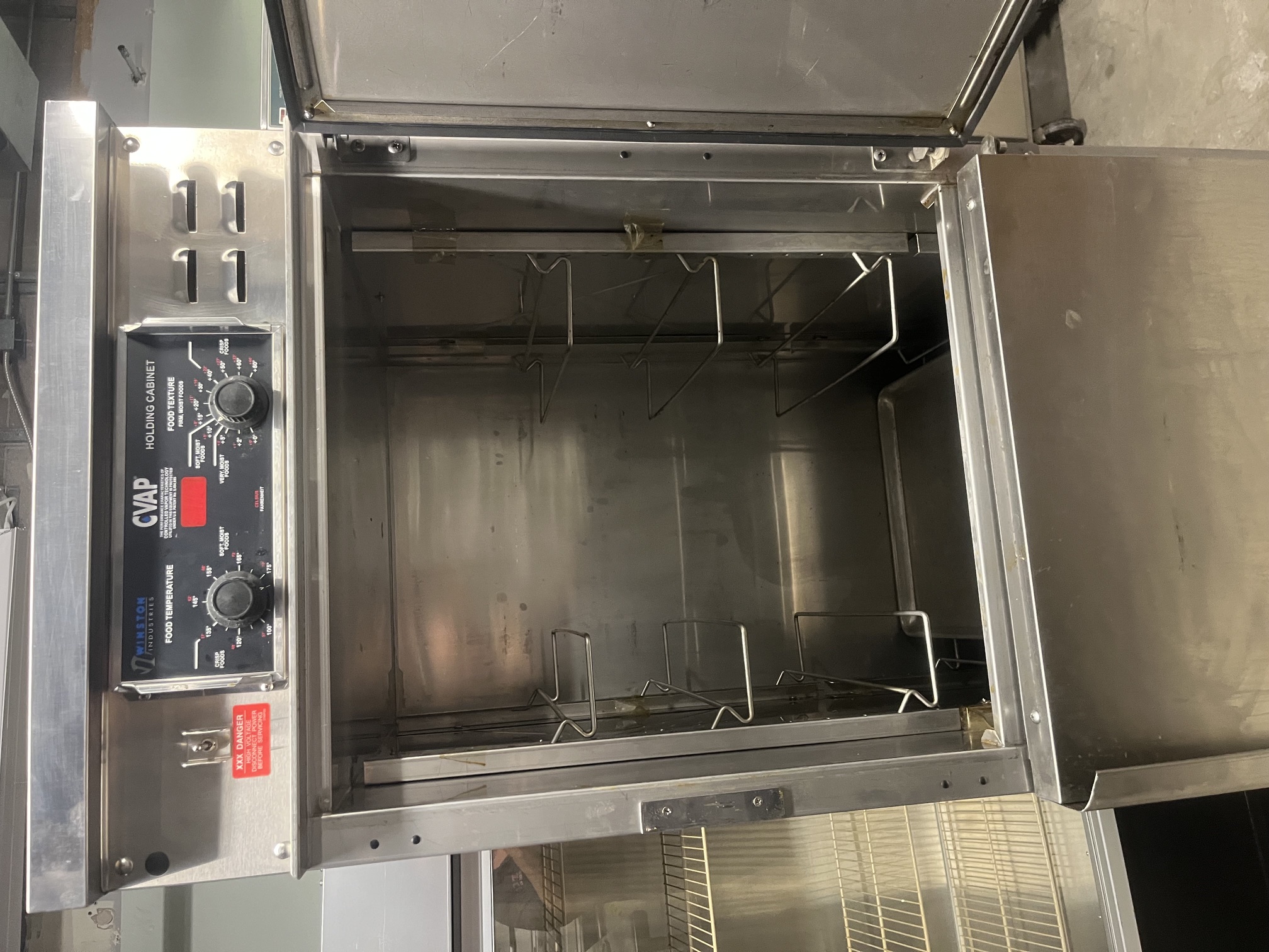 Winston CVAP holding cabinet with upper door open revealing stainless steel interior with wire pan slide racks and water reservoir at the bottom