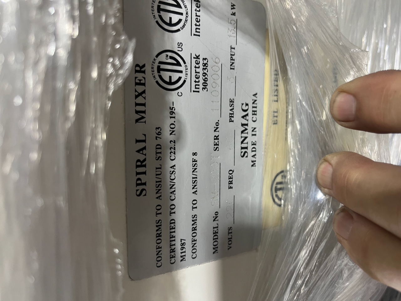Close-up of Sinmag SM-200T data plate showing model number, serial number 1109006, 220V 3-phase, 13.5 kW specifications