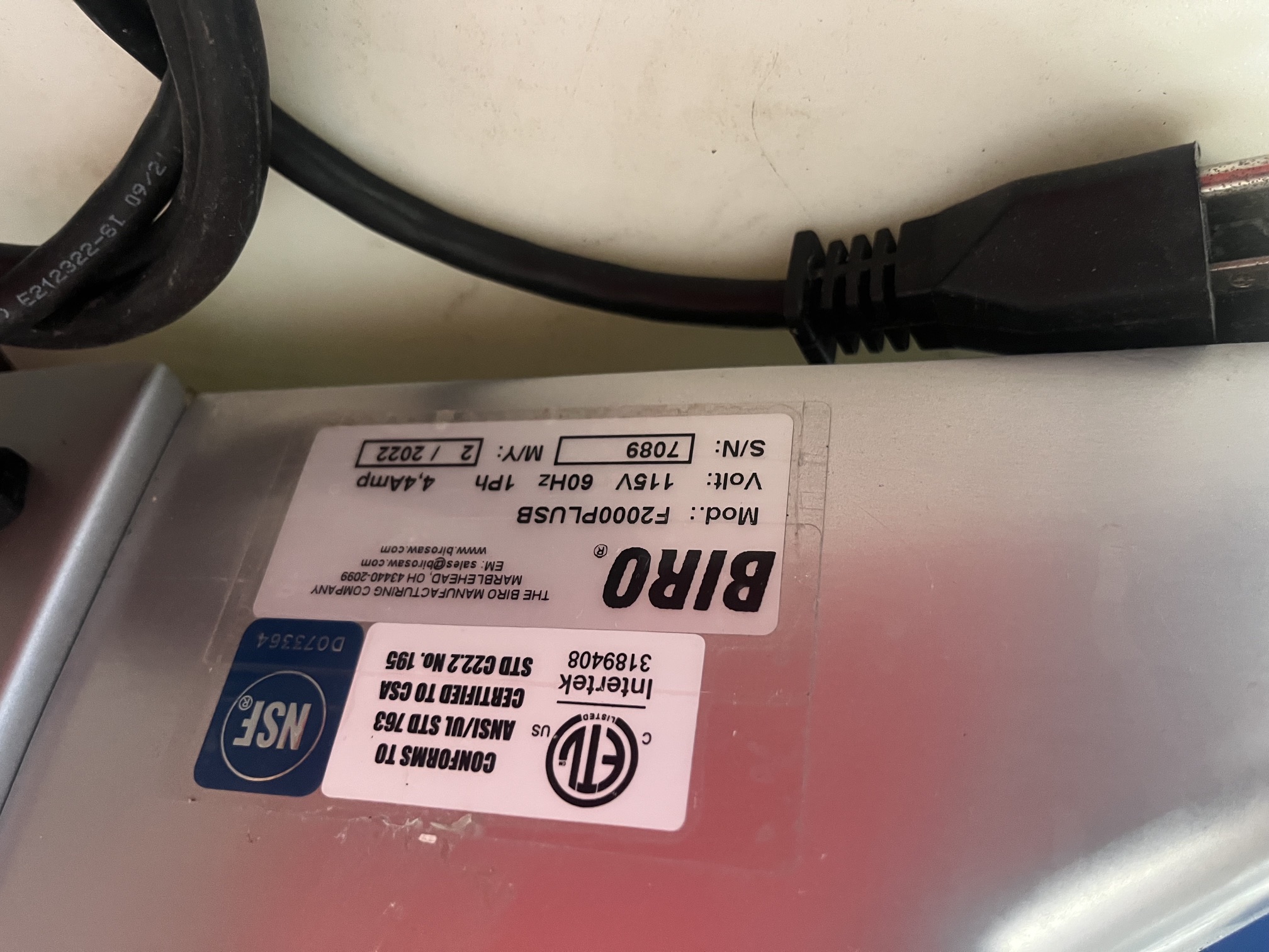 Close-up of Biro F2000PLUSB data plate showing model number, 115V 60Hz 1Ph 4.4 Amp electrical specs, serial number 7089, manufactured February 2022, with ETL and NSF certifications