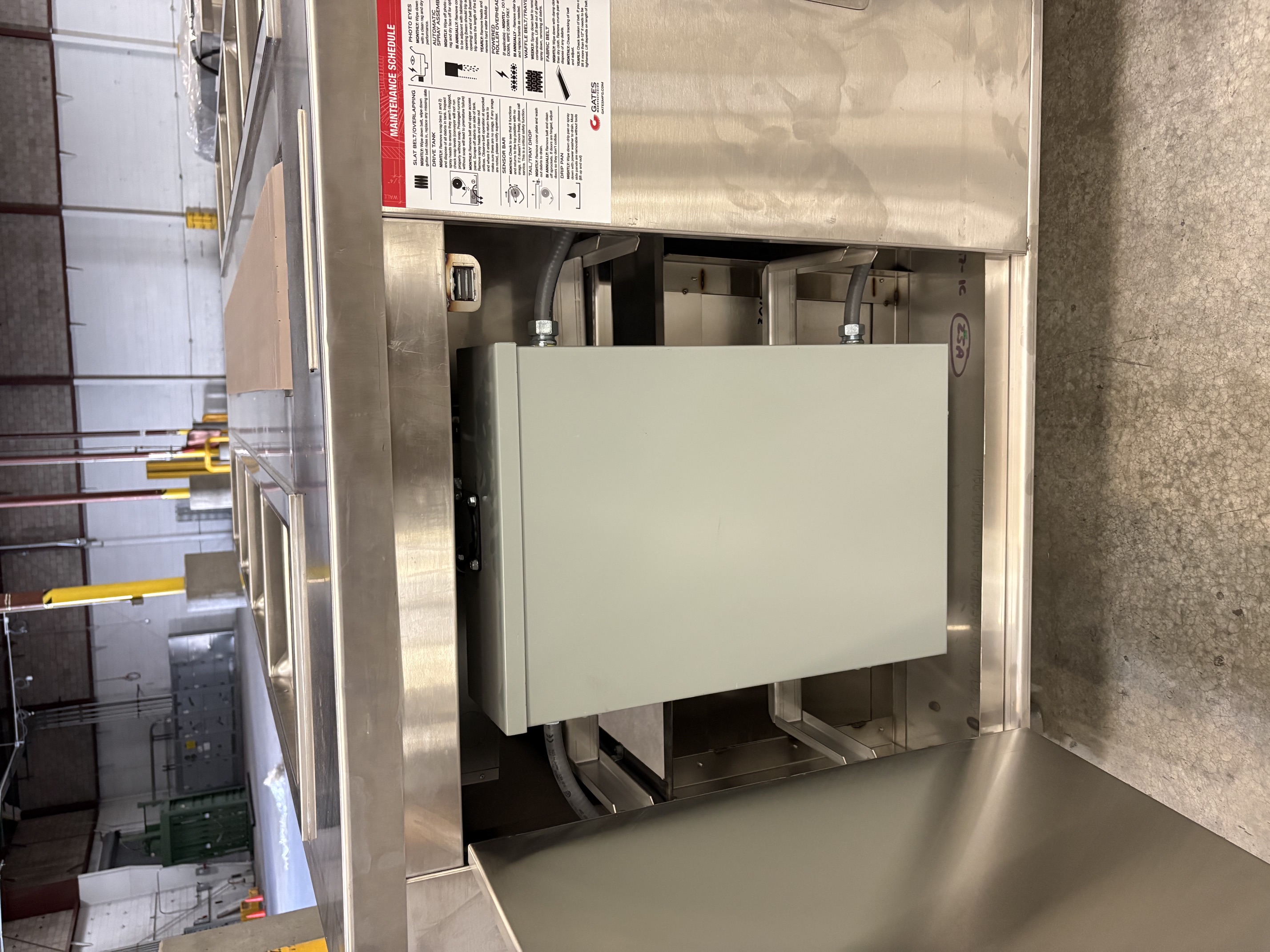 Interior view of conveyor with access panel open showing electrical junction box and internal components
