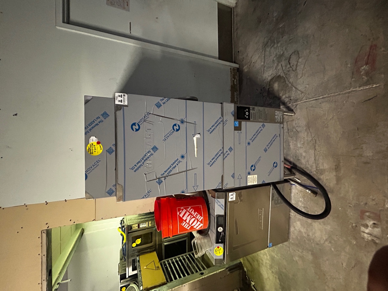 Front view of new Hobart AM16VLT-BAS ventless door-type dishwasher with factory Novacel protective film still applied, showing digital control panel and door handle