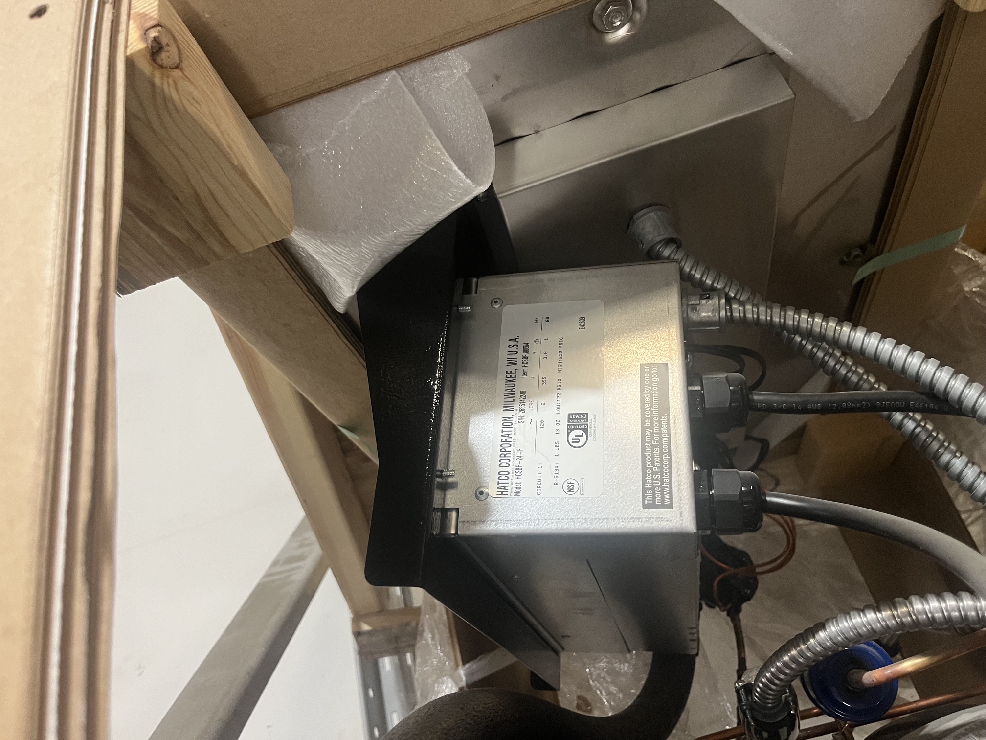 Close-up of Hatco HCSBF-24-F data plate showing model number, serial number, electrical specifications, UL and NSF certifications, with factory wiring and conduit visible