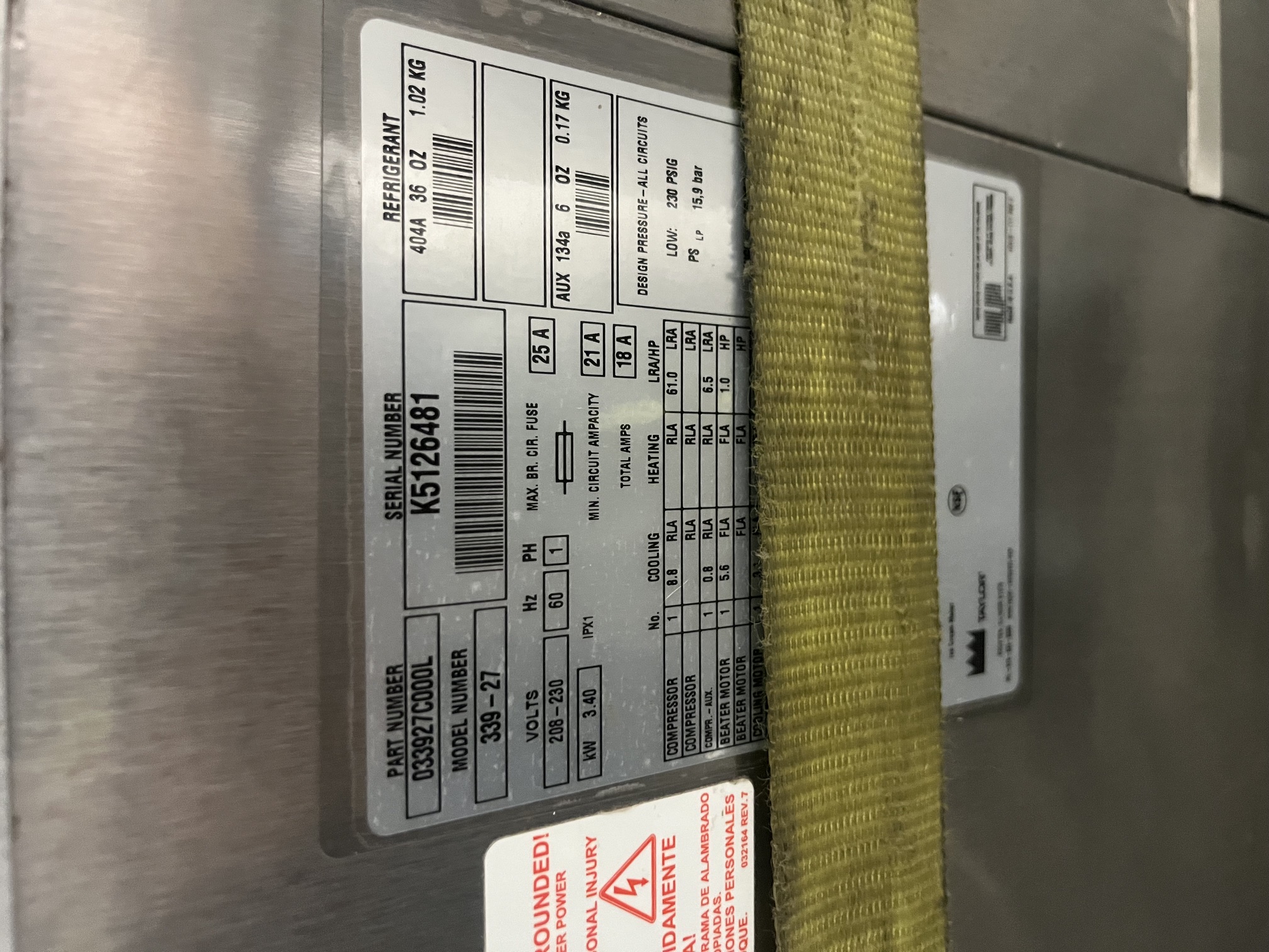 Close-up of Taylor 339-27 data plate showing model number, serial number K5126481, 208-230V single phase electrical specs, and refrigerant information