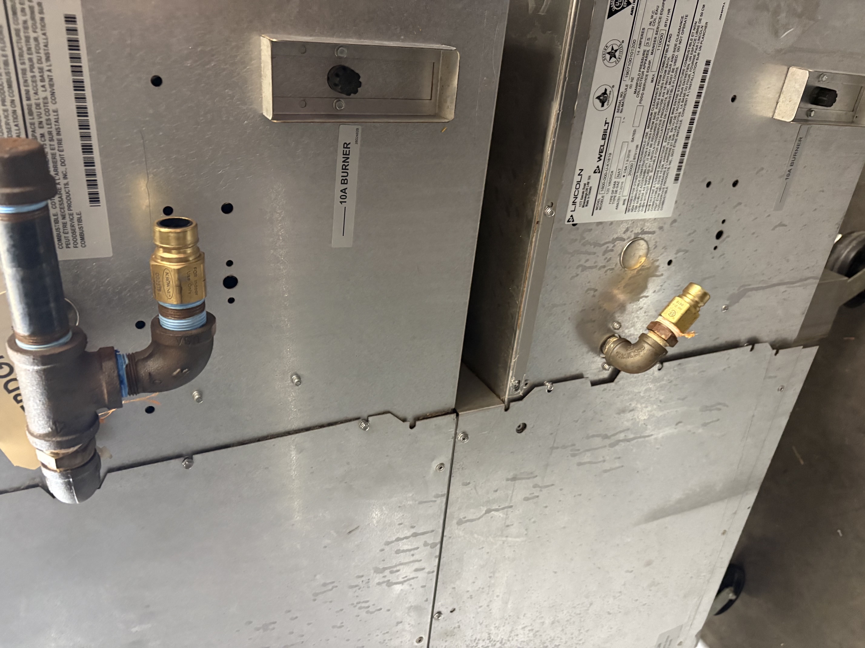 Close-up of the rear gas connections and data plate on Lincoln Impinger 1600 showing 10A burner label and gas piping
